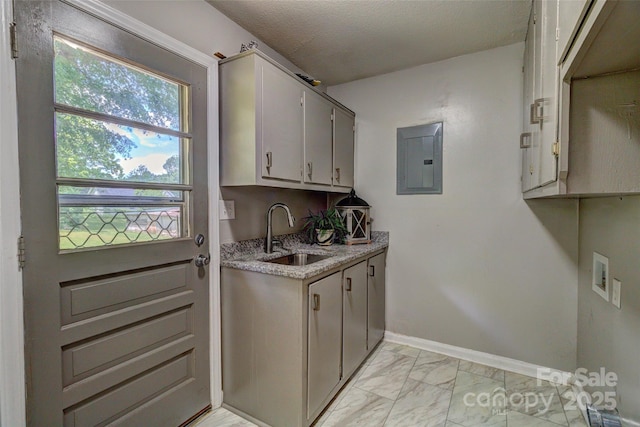 laundry area featuring a sink, electric panel, marble finish floor, washer hookup, and baseboards