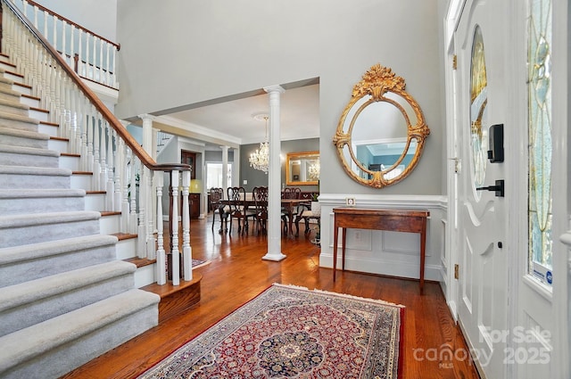 5718 Bardsey Ct, Matthews, NC 28104 - foyer featuring wood finished floors, stairs, ornate columns, a high ceiling, and crown molding