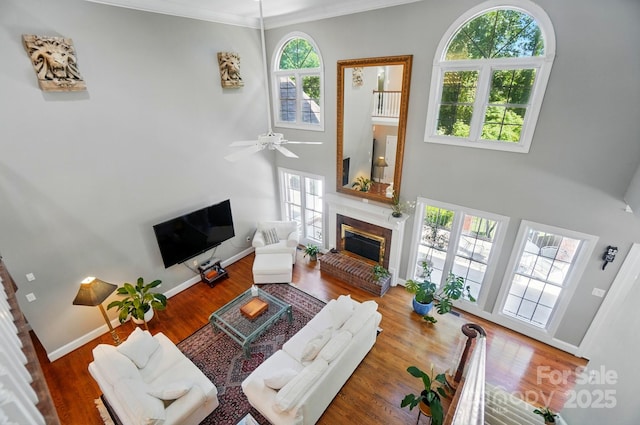 5718 Bardsey Ct, Matthews, NC 28104 - living room with a brick fireplace, plenty of natural light, wood finished floors, a towering ceiling, and ornamental molding