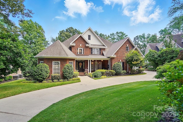 5718 Bardsey Ct, Matthews, NC 28104 - traditional home with brick siding, a front yard, a porch, and roof with shingles