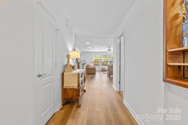 corridor featuring light wood-style floors, baseboards, and recessed lighting