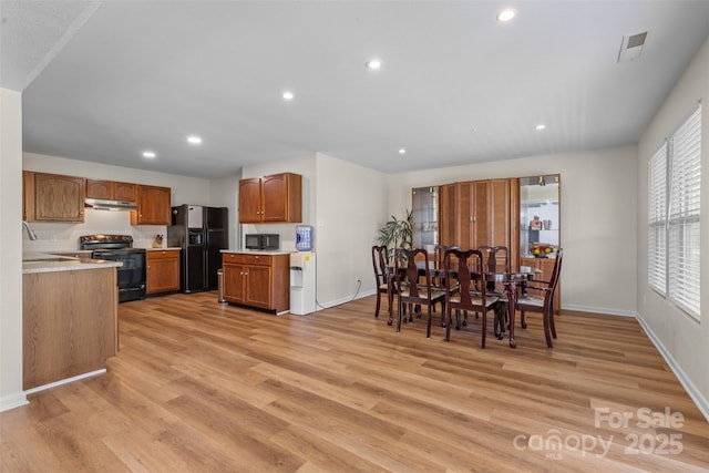 dining space featuring light wood-style flooring, recessed lighting, and baseboards