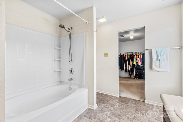 bathroom with baseboards, shower / bathtub combination, and vanity