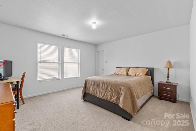 bedroom featuring light colored carpet, baseboards, and an office area
