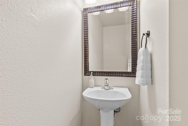 bathroom featuring a textured wall