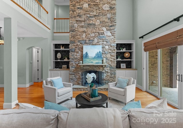 3815 Stoney Ridge Trl, Charlotte, NC 28210 - living area featuring a towering ceiling, wood finished floors, arched walkways, a fireplace, and baseboards