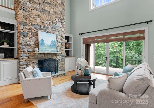 3815 Stoney Ridge Trl, Charlotte, NC 28210 - living area featuring plenty of natural light, a stone fireplace, wood finished floors, and a high ceiling
