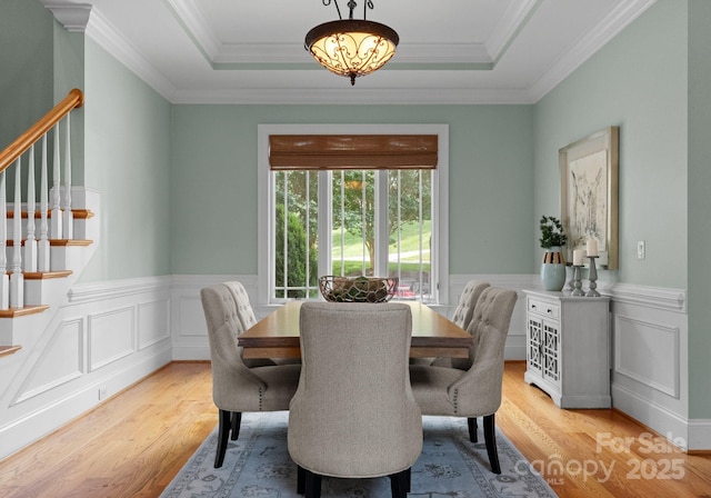 3815 Stoney Ridge Trl, Charlotte, NC 28210 - dining area featuring stairway, light wood-type flooring, a tray ceiling, a wainscoted wall, and ornamental molding
