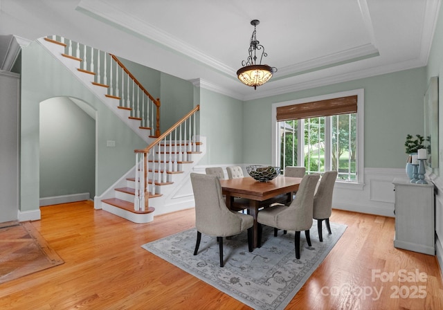 3815 Stoney Ridge Trl, Charlotte, NC 28210 - dining room with a tray ceiling, crown molding, stairway, light wood finished floors, and wainscoting