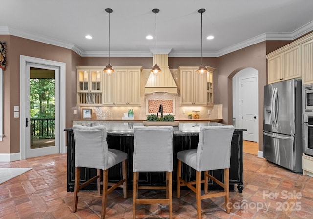 3815 Stoney Ridge Trl, Charlotte, NC 28210 - kitchen with cream cabinetry, stainless steel appliances, arched walkways, backsplash, and a breakfast bar area