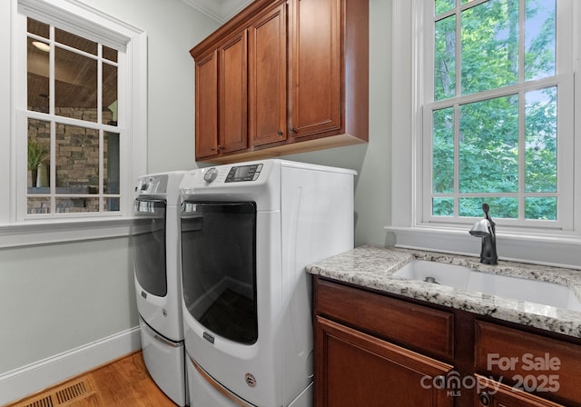 3815 Stoney Ridge Trl, Charlotte, NC 28210 - laundry room featuring washing machine and clothes dryer, cabinet space, light wood-type flooring, and baseboards