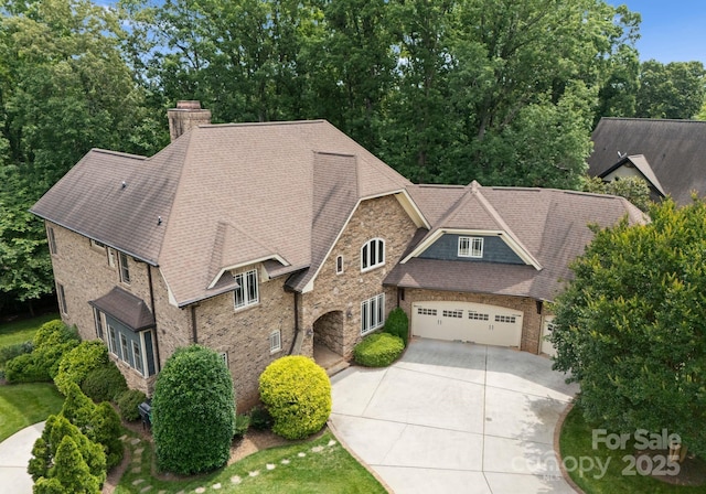 3815 Stoney Ridge Trl, Charlotte, NC 28210 - view of front of property with driveway, a chimney, a garage, stone siding, and brick siding