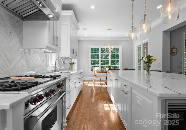 12835 Ninebark Trl, Charlotte, NC 28278 - kitchen with high end stainless steel range oven, wall chimney exhaust hood, a sink, recessed lighting, and white cabinetry
