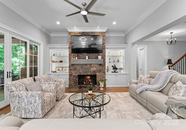 12835 Ninebark Trl, Charlotte, NC 28278 - living area with wood finished floors, a stone fireplace, a ceiling fan, ornamental molding, and a chandelier