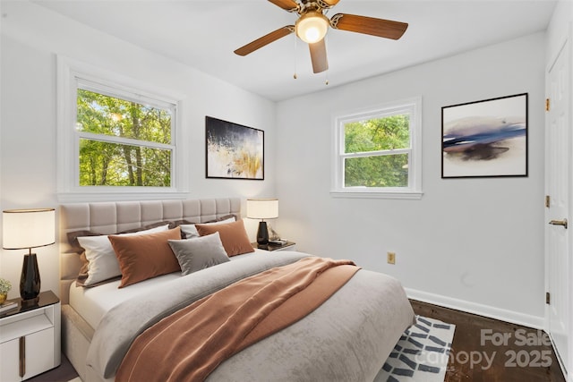 bedroom with a ceiling fan, wood finished floors, and baseboards