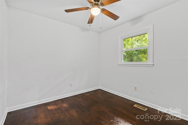 unfurnished room featuring baseboards, visible vents, a ceiling fan, and dark wood-type flooring
