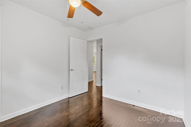 empty room featuring baseboards, a ceiling fan, and wood finished floors