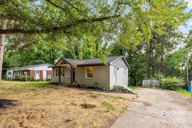 ranch-style house with covered porch, brick siding, and driveway