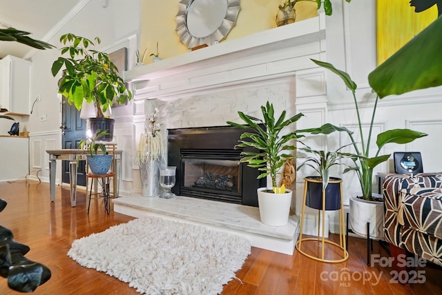 6221 Thermal Rd, Charlotte, NC 28211 - living area featuring a premium fireplace, wood finished floors, a decorative wall, and crown molding