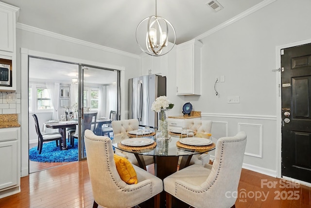 6221 Thermal Rd, Charlotte, NC 28211 - dining room with a chandelier, wood finished floors, crown molding, and a wainscoted wall