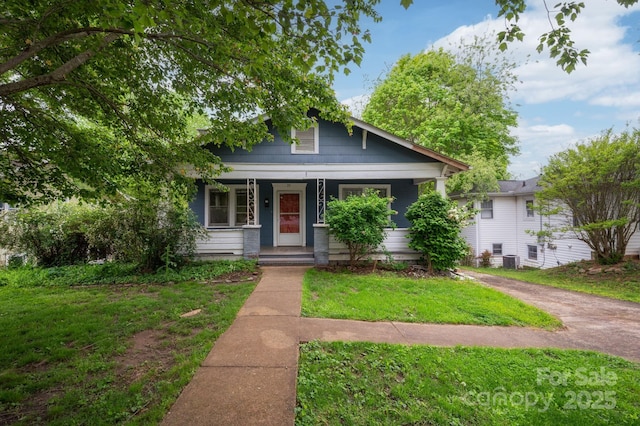 bungalow-style home with a front lawn, central AC, and covered porch