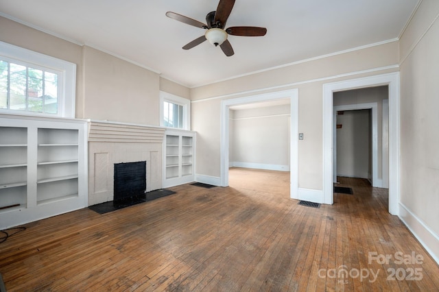 unfurnished living room featuring a fireplace with flush hearth, hardwood / wood-style floors, visible vents, ceiling fan, and ornamental molding