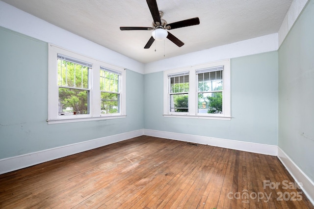 spare room featuring baseboards, ceiling fan, and hardwood / wood-style flooring