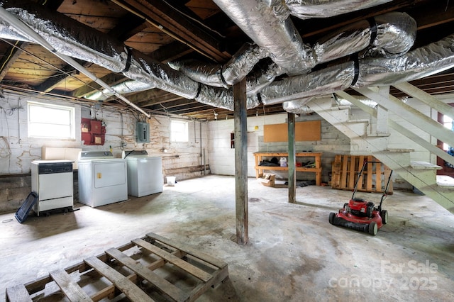 basement featuring electric panel, stairway, and washer and dryer