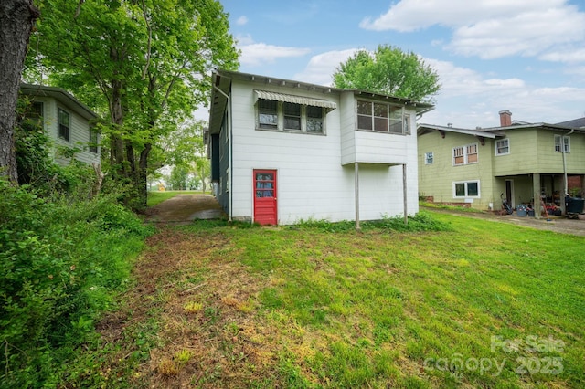 rear view of property featuring a yard