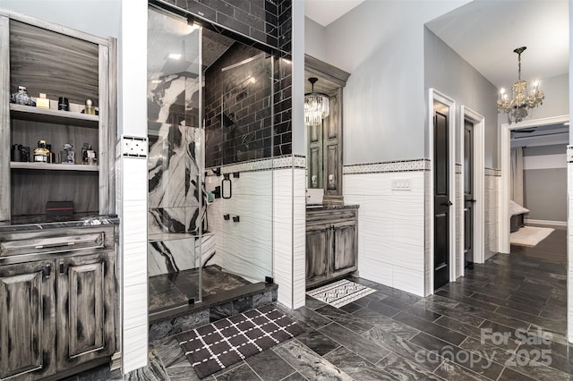 16109 Reynolds Dr, Indian Land, SC 29707 - bathroom with a chandelier, a stall shower, tile walls, and vanity