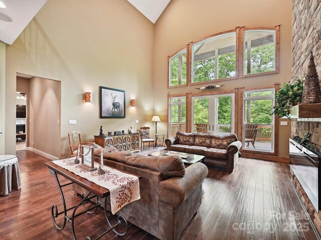 1140 Fern Hill Rd, Mooresville, NC 28117 - living room featuring high vaulted ceiling, dark wood-type flooring, baseboards, and a fireplace