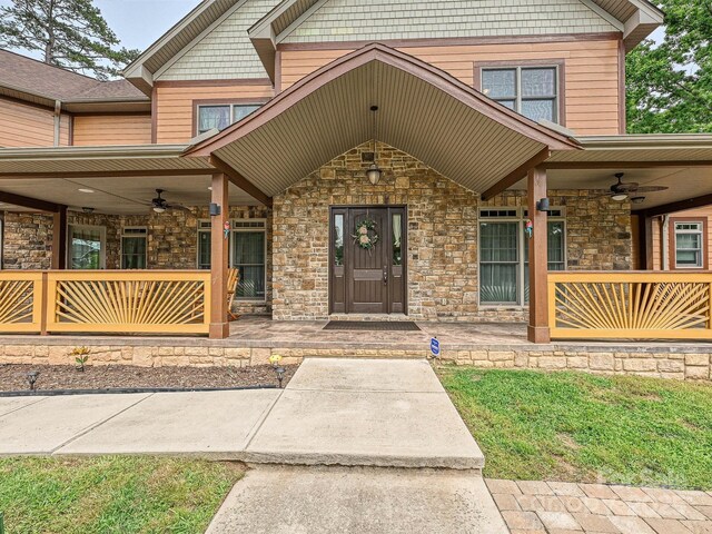 1140 Fern Hill Rd, Mooresville, NC 28117 - doorway to property with a ceiling fan, covered porch, and stone siding