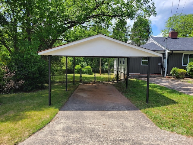 view of front of home featuring driveway, a carport, and a chimney