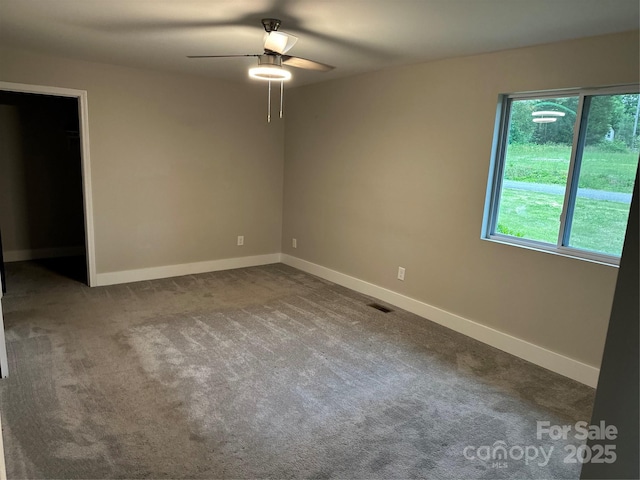 unfurnished room featuring ceiling fan, baseboards, and dark colored carpet