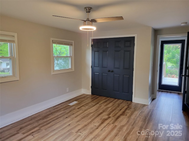 foyer entrance with plenty of natural light, baseboards, light wood finished floors, and ceiling fan