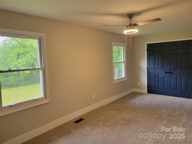 unfurnished bedroom with baseboards, carpet, and a ceiling fan