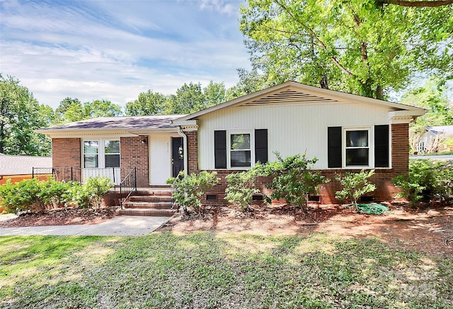 single story home featuring brick siding, a front yard, and crawl space