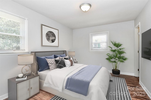 bedroom with wood finished floors and baseboards