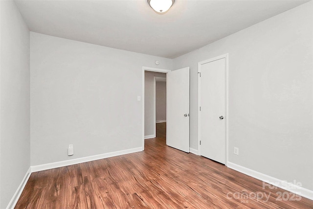unfurnished room featuring wood finished floors and baseboards