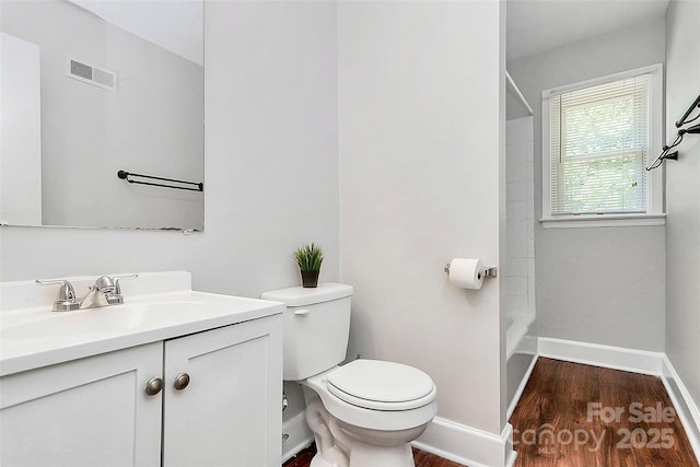 full bathroom with toilet, wood finished floors, vanity, visible vents, and baseboards