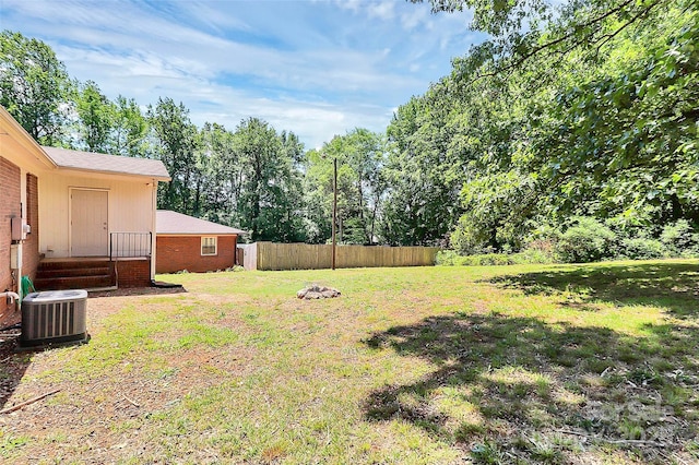 view of yard featuring central AC unit and entry steps