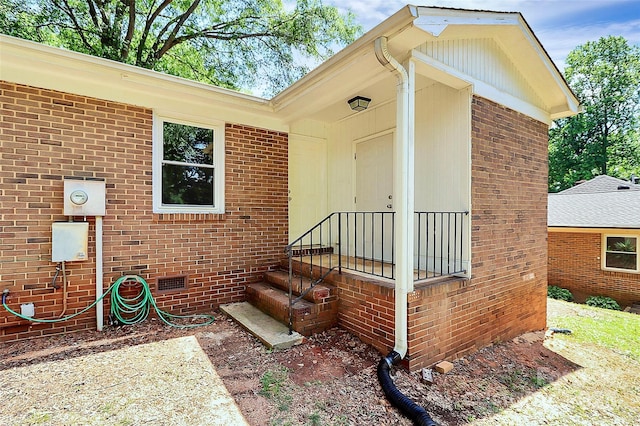 doorway to property with brick siding and crawl space