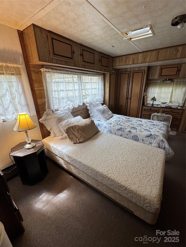 bedroom with carpet flooring and wood walls