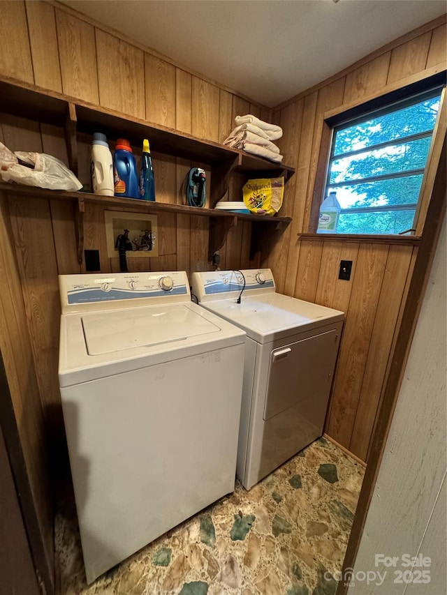laundry room featuring laundry area, wooden walls, and washing machine and dryer