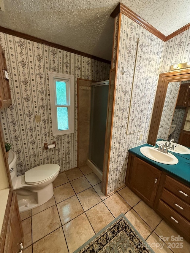 bathroom with ornamental molding, a textured ceiling, a stall shower, vanity, and toilet