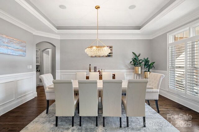 18823 Peninsula Cove Ln, Cornelius, NC 28031 - dining space featuring a tray ceiling, arched walkways, dark wood finished floors, a chandelier, and wainscoting