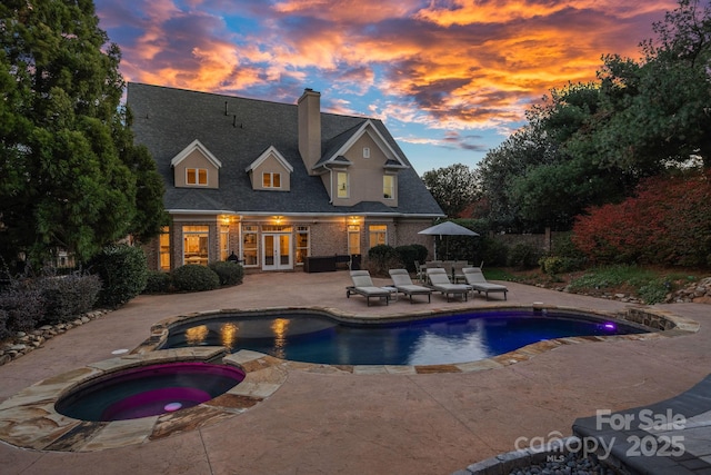 18823 Peninsula Cove Ln, Cornelius, NC 28031 - pool at dusk featuring french doors, a patio area, and a pool with connected hot tub