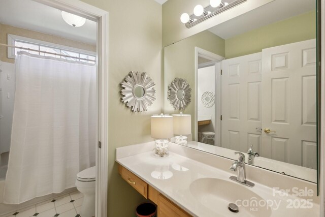 bathroom featuring toilet, vanity, and shower / tub combo with curtain