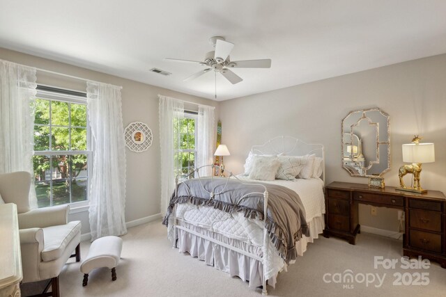 bedroom featuring carpet flooring, multiple windows, visible vents, and baseboards