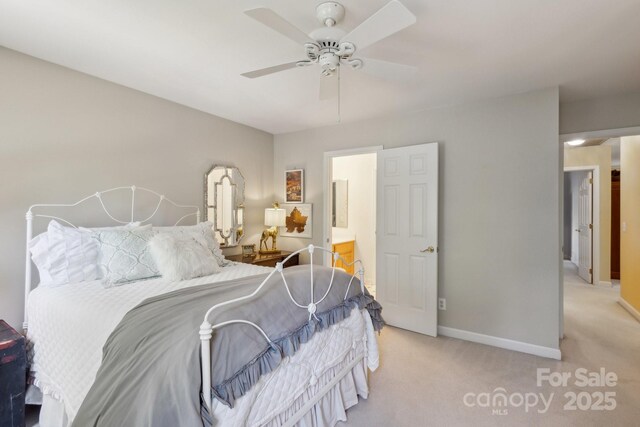 carpeted bedroom featuring ensuite bathroom, baseboards, and a ceiling fan